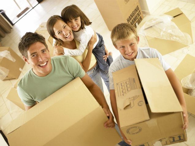 Apartments for rent in Spring TX A family moving into their new apartment in Spring TX, joyfully holding boxes in a room.