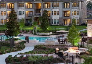 Apartments in Tomball, TX - Community View of Pool, Fire Pit and Apartment Buildings Lit Up